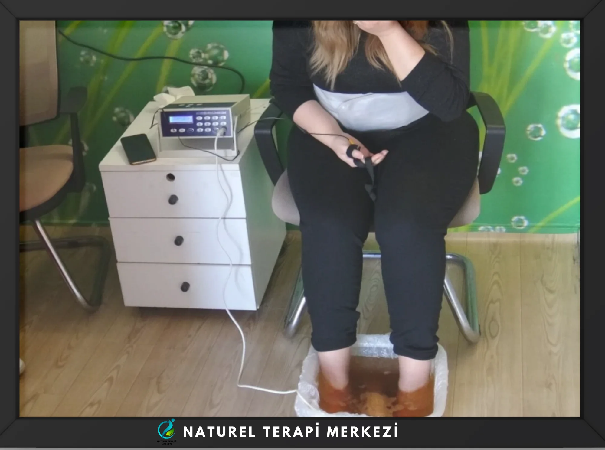 El ve ayak detoksu uygulaması sırasında ayakların detoks cihazına yerleştirildiği seans – Naturel Terapi Merkezi